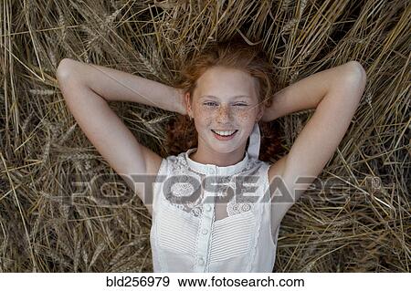 Caucasian girl laying in wheat View Large Photo Image Stock Photo - Caucasian girl laying in wheat. Fotosearch