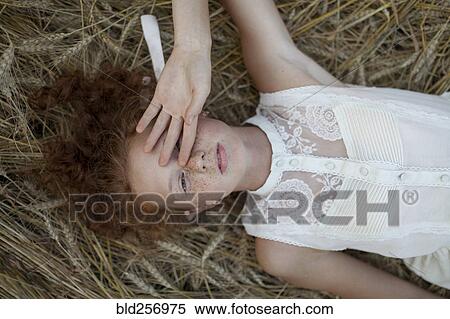 Stock Photography - Caucasian girl laying in wheat. Fotosearch