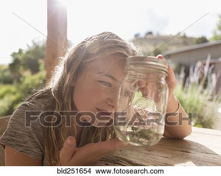 Caucasian girl looking at jar View Large Photo Image Picture - Caucasian girl looking at jar. Fotosearch