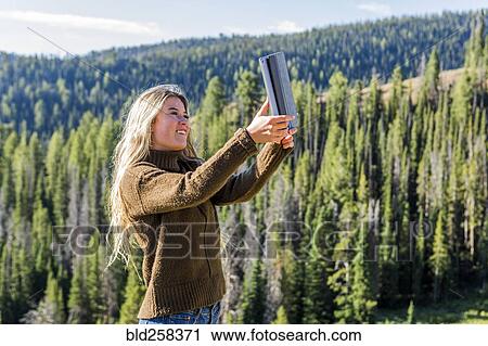 Caucasian girl photographing landscape with digital tablet View Large Photo Image Stock Image - Caucasian girl photographing landscape with digital tablet. Fotosearch