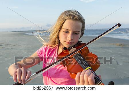 Caucasian girl playing violin on windy beach View Large Photo Image Stock Photo - Caucasian girl playing violin on windy beach. Fotosearch