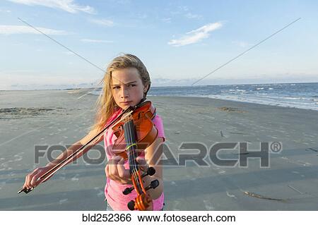 Caucasian girl playing violin on windy beach View Large Photo Image Stock Photograph - Caucasian girl playing violin on windy beach. Fotosearch