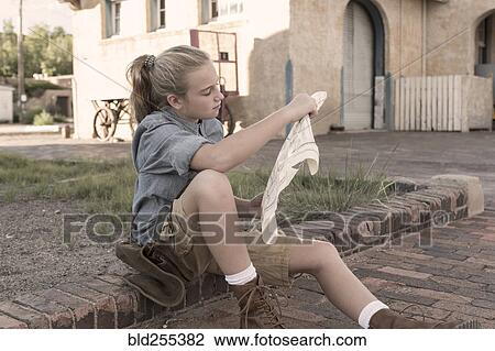 Stock Image - Caucasian girl reading map. Fotosearch