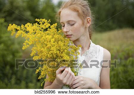Caucasian girl smelling wildflowers View Large Photo Image Stock Photograph - Caucasian girl smelling wildflowers. Fotosearch