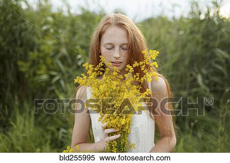 Caucasian girl smelling wildflowers View Large Photo Image Stock Photography - Caucasian girl smelling wildflowers. Fotosearch