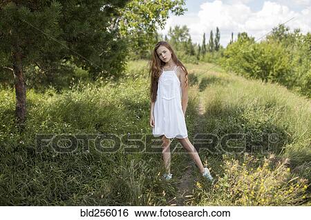 Stock Photograph - Caucasian girl standing in field of grass. Fotosearch