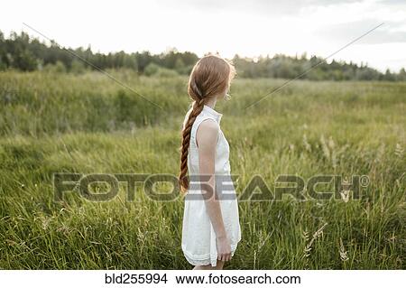 Picture - Caucasian girl standing in field. Fotosearch
