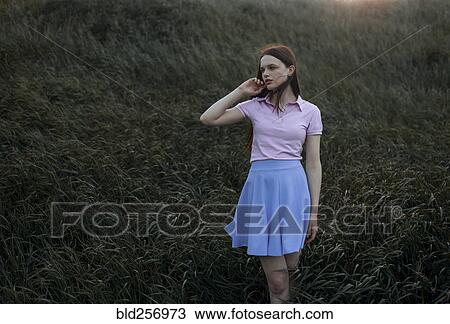 Caucasian girl standing in windy field View Large Photo Image Stock Image - Caucasian girl standing in windy field. Fotosearch
