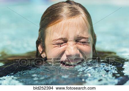 Picture - Caucasian girl swimming with eyes closed. Fotosearch