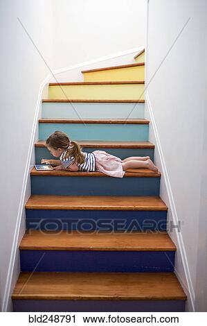 Caucasian girl using digital tablet on multicolor staircase View Large Photo Image Stock Image - Caucasian girl using digital tablet on multicolor staircase. Fotosearch