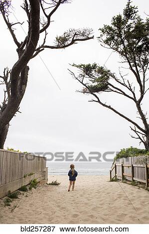 Stock Photo - Caucasian girl walking on beach. Fotosearch