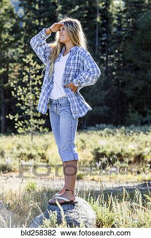 Caucasian girl wearing plaid shirt standing on rock View Large Photo Image Stock Image - Caucasian girl wearing plaid shirt standing on rock. Fotosearch
