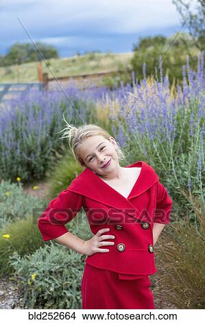 Picture - Caucasian girl wearing red dress in field. Fotosearch