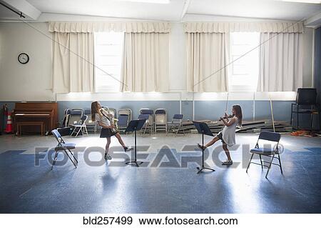 Stock Photo - Caucasian girls 1acticing violins and dancing. Fotosearch