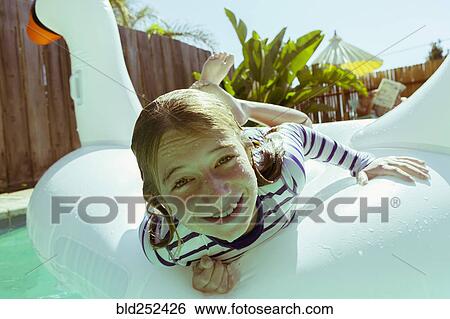 Caucasian girls laying on inflatable swan in swimming pool View Large Photo Image Stock Photograph - Caucasian girls laying on inflatable swan in swimming pool. Fotosearch