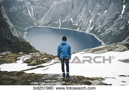 Caucasian man admiring scenic view of mountain lake View Large Photo Image Stock Image - Caucasian man admiring scenic view of mountain lake. Fotosearch