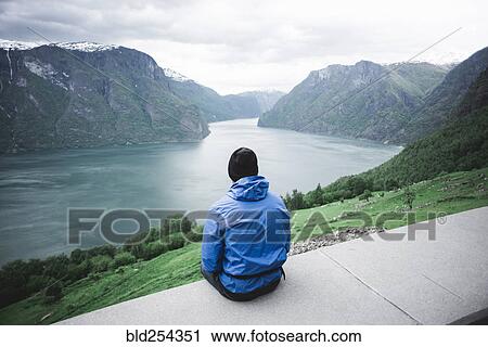 Stock Image - Caucasian man admiring scenic view of river. Fotosearch