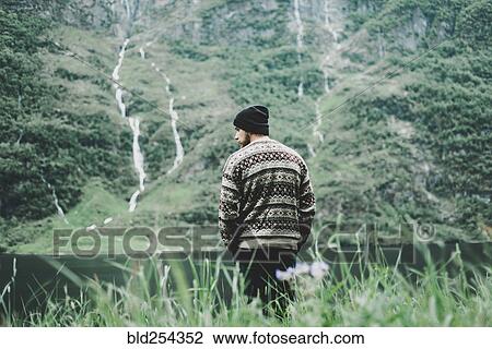 Stock Image - Caucasian man admiring scenic view of river. Fotosearch