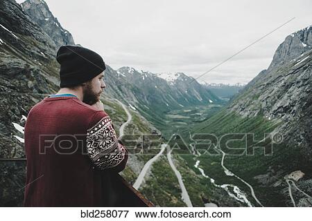 Stock Photo - Caucasian man admiring scenic view of valley. Fotosearch