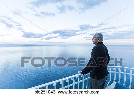 Caucasian man admiring scenic view on waterfront balcony View Large Photo Image Stock Image - Caucasian man admiring scenic view on waterfront balcony. Fotosearch