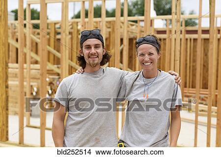 Picture - Caucasian man and woman posing at construction site. Fotosearch