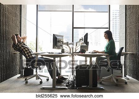 Caucasian man and woman using computers in office View Large Photo Image Stock Photography - Caucasian man and woman using computers in office. Fotosearch