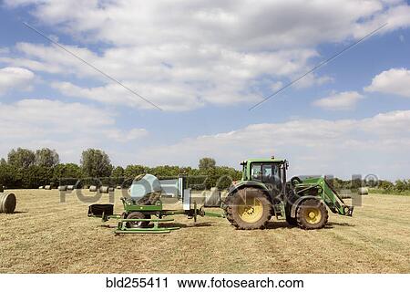 Caucasian man driving tractor baling hay View Large Photo Image Stock Image - Caucasian man driving tractor baling hay. Fotosearch