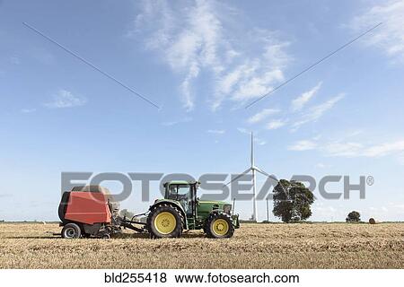 Caucasian man driving tractor near wind turbine View Large Photo Image Stock Photo - Caucasian man driving tractor near wind turbine. Fotosearch