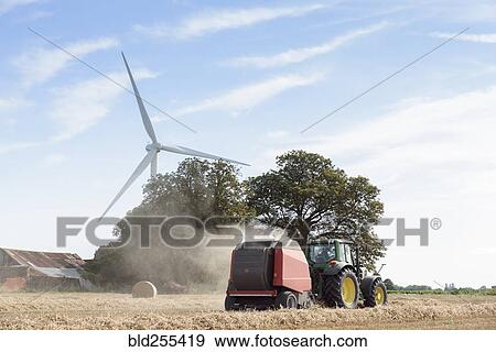 Caucasian man driving tractor near wind turbine View Large Photo Image Stock Photo - Caucasian man driving tractor near wind turbine. Fotosearch