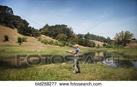 Stock Photo - Caucasian man fishing at river. Fotosearch