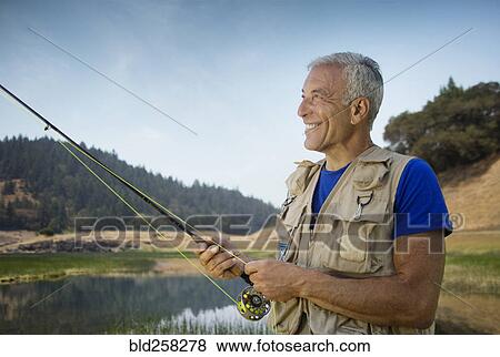 Stock Photo - Caucasian man fishing at river. Fotosearch