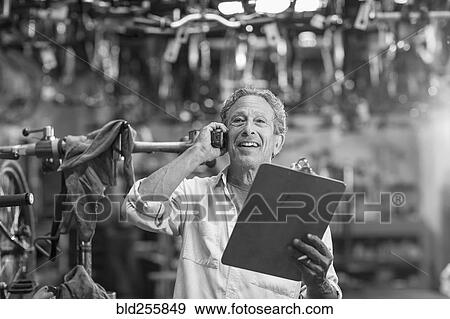 Caucasian man in bicycle shop talking on telephone View Large Photo Image Stock Photo - Caucasian man in bicycle shop talking on telephone. Fotosearch