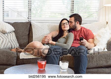 Caucasian man kissing cheek of woman on sofa View Large Photo Image Stock Photography - Caucasian man kissing cheek of woman on sofa. Fotosearch