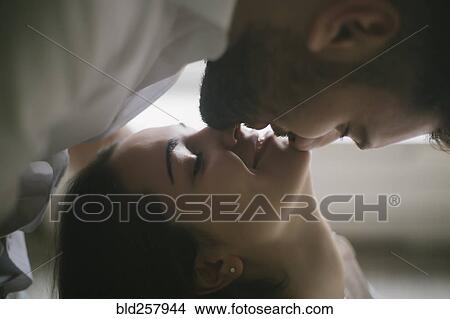 Caucasian man leaning over and kissing woman View Large Photo Image Picture - Caucasian man leaning over and kissing woman. Fotosearch
