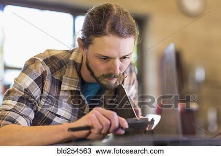 Caucasian man measuring metal with caliper View Large Photo Image Stock Image - Caucasian man measuring metal with caliper. Fotosearch