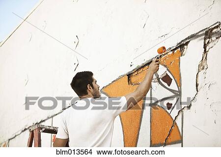 Picture - Caucasian man painting wall. Fotosearch