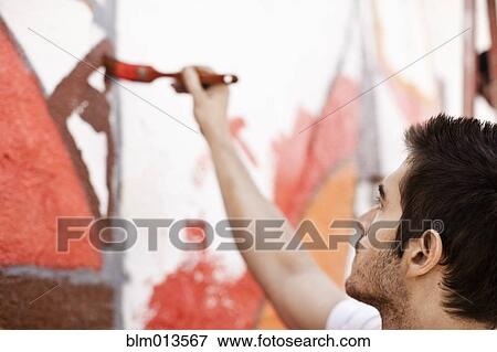 Stock Photo - Caucasian man painting wall. Fotosearch