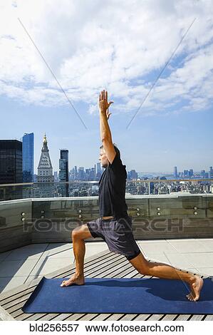Caucasian man practicing yoga on urban rooftop View Large Photo Image Stock Photo - Caucasian man practicing yoga on urban rooftop. Fotosearch