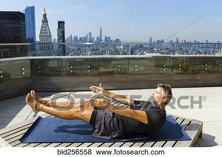 Caucasian man practicing yoga on urban rooftop View Large Photo Image Stock Photo - Caucasian man practicing yoga on urban rooftop. Fotosearch