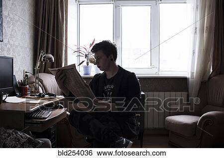 Stock Photograph - Caucasian man reading newspaper at this. Fotosearch