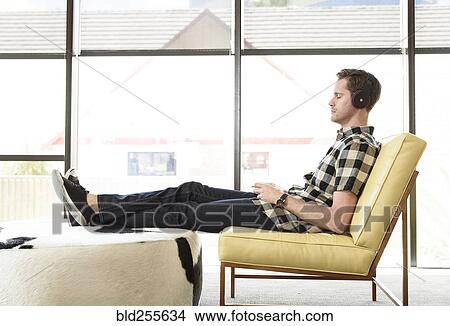 Caucasian man relaxing and listening to headphones View Large Photo Image Picture - Caucasian man relaxing and listening to headphones. Fotosearch