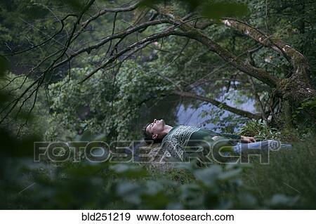 Stock Photo - Caucasian man relaxing in woods. Fotosearch