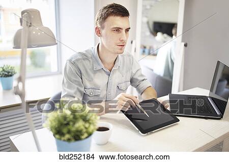 Caucasian man showing digital tablet View Large Photo Image Picture - Caucasian man showing digital tablet. Fotosearch