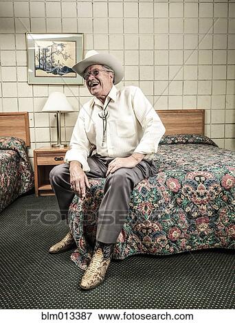Stock Photo - Caucasian man sitting in hotel room. Fotosearch
