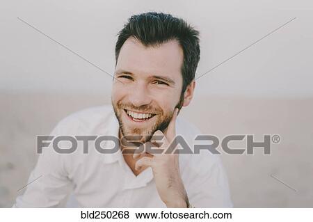 Caucasian man sitting on beach View Large Photo Image Stock Photo - Caucasian man sitting on beach. Fotosearch