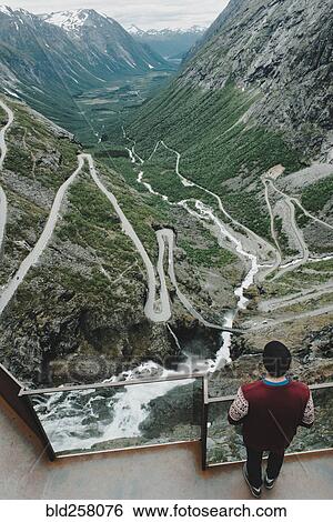 Caucasian man standing at viewpoint admiring scenic view of valley View Large Photo Image Stock Photograph - Caucasian man standing at viewpoint admiring scenic view of valley. Fotosearch