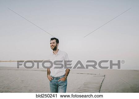 Caucasian man standing on beach View Large Photo Image Stock Image - Caucasian man standing on beach. Fotosearch