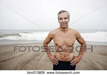 Caucasian man standing on beach View Large Photo Image Stock Photo - Caucasian man standing on beach. Fotosearch