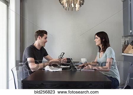Stock Image - Caucasian man talking to woman with laptop. Fotosearch