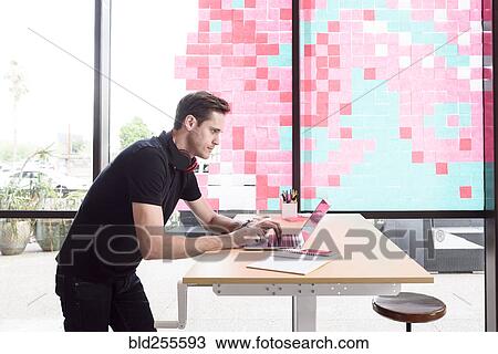 Stock Image - Caucasian man typing on laptop. Fotosearch